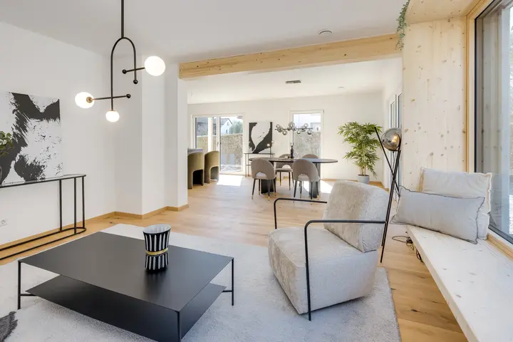 Sitzbereich mit Sessel, schwarzem Couchtisch und Pendelleuchte