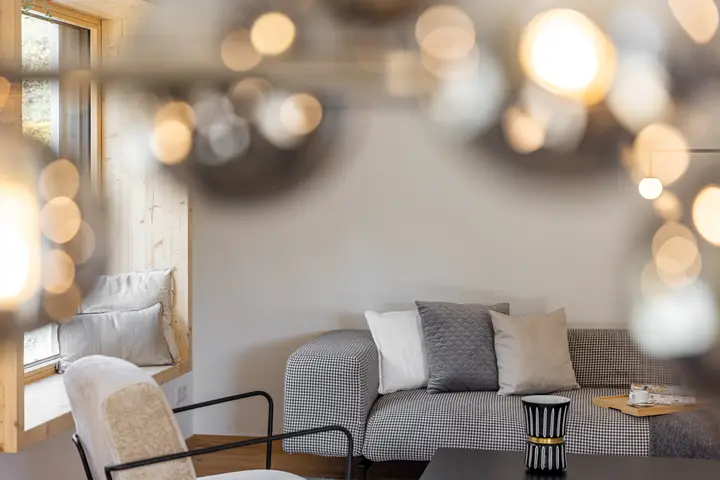 Wohnbereich mit Sofa hinter einer unscharfen Glaskugelleuchte