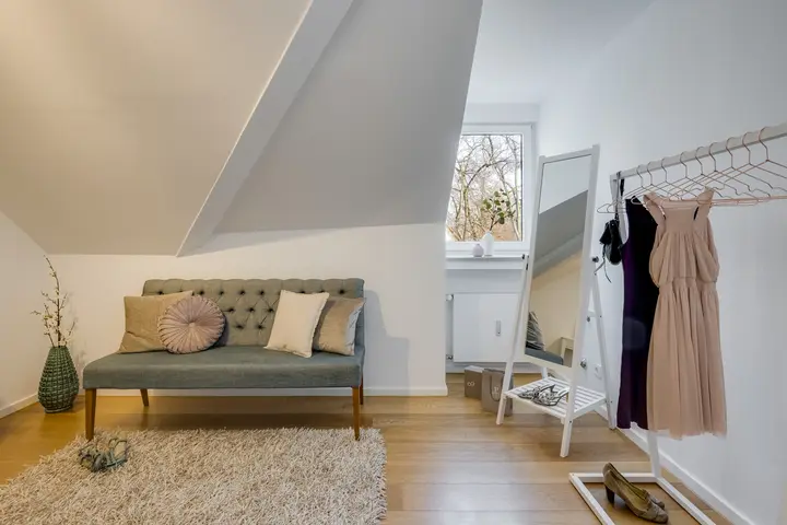 Ankleide im Dachgeschoss mit Kleiderständer und Sitzbank