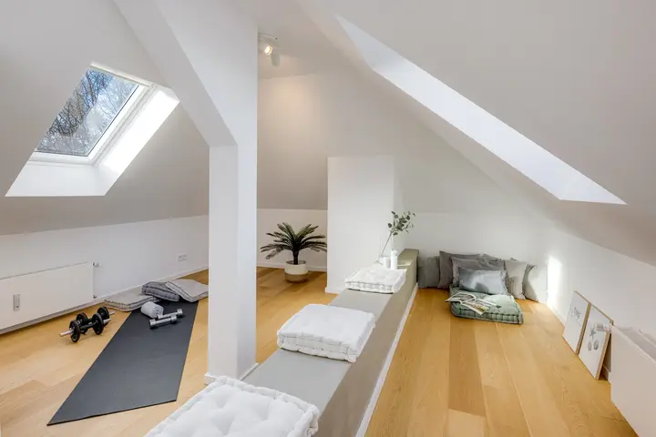 Schmaler Raum unter dem Dachfenster mit Sitzbereich