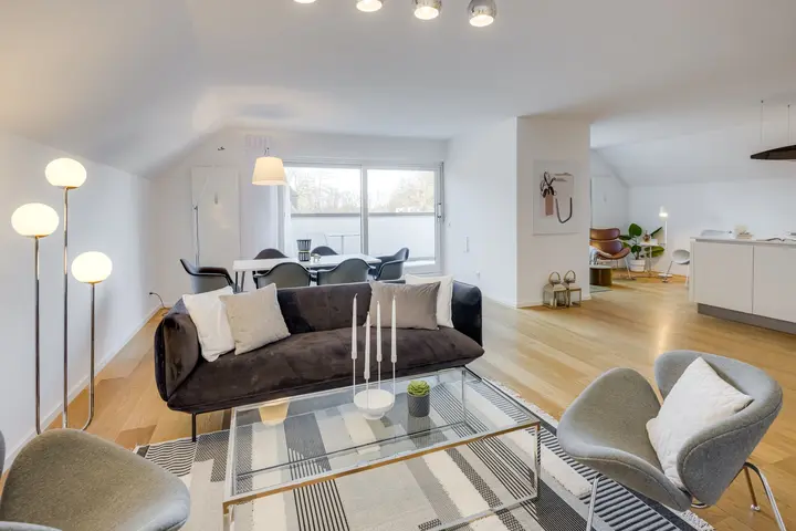 Wohnzimmer mit Sofa und Glastisch unter der Dachschräge