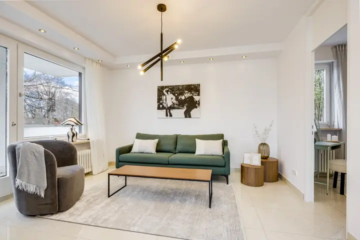 Wohnzimmer mit grünem Sofa und Couchtisch