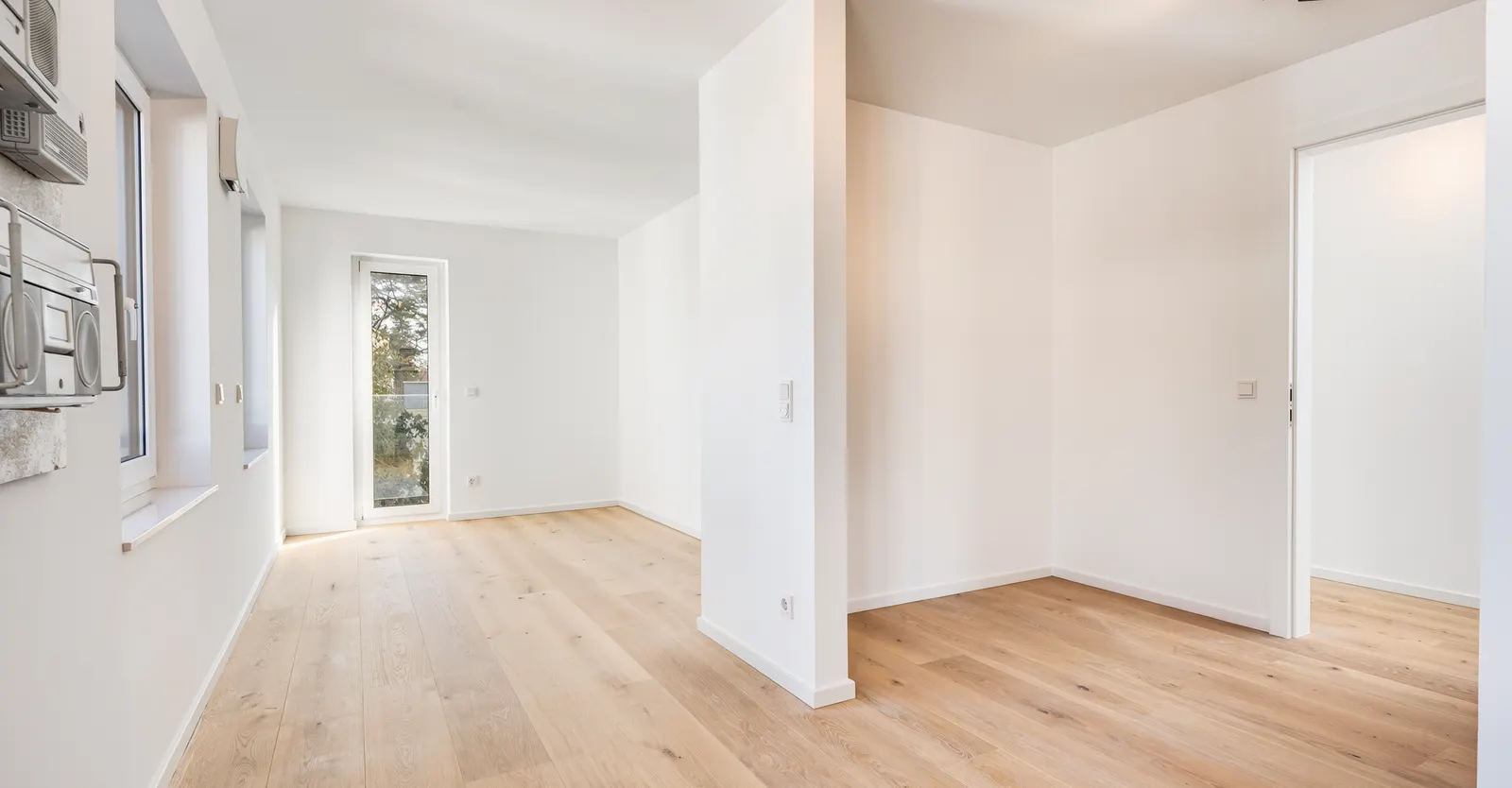 Leerer Schlaf- und Arbeitsbereich mit Holzboden vor dem Home Staging