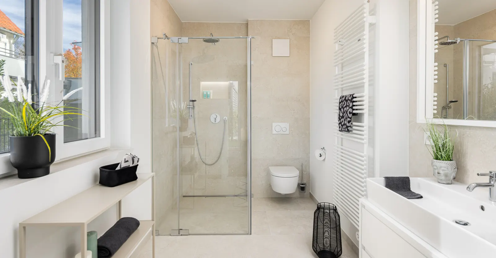 Bad mit Dusche nach dem Home Staging, dekoriert mit Handtüchern und Pflanzen