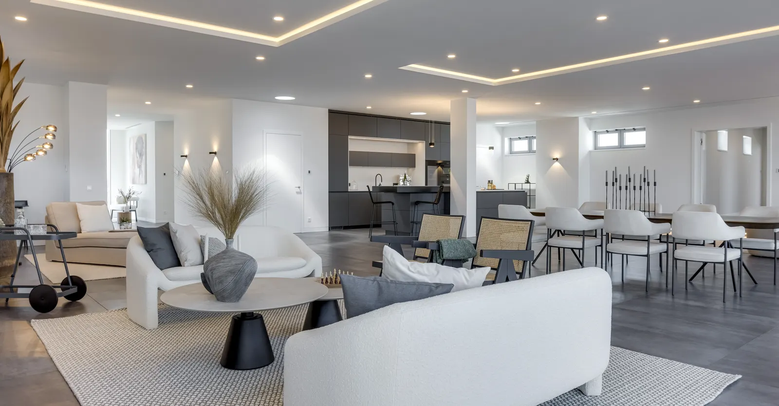 Offener Wohn- und Essbereich mit Sofas und langer Tafel in einem Penthouse nach dem Home Staging