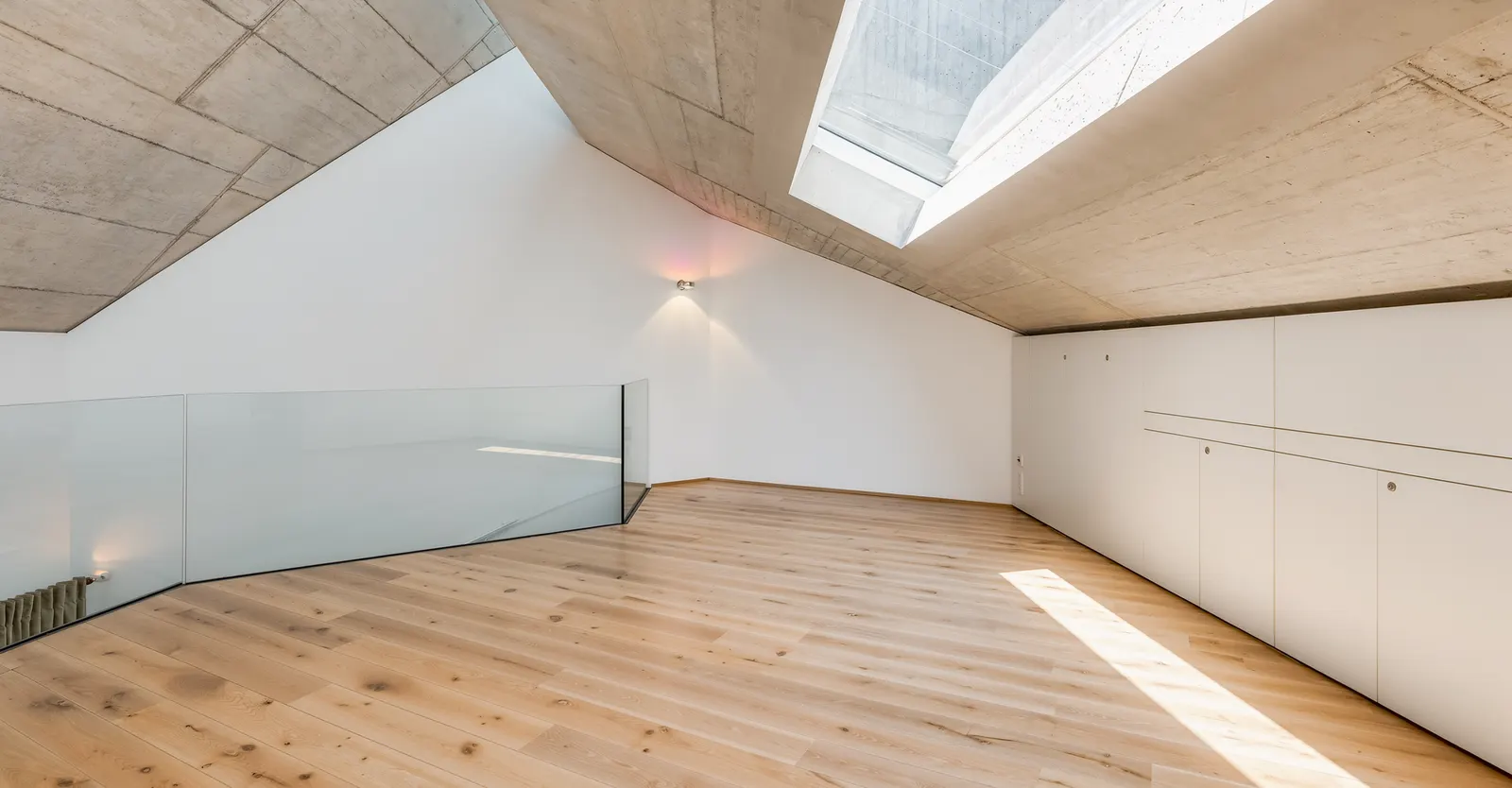 Leere Galerie unter der Dachschräge mit Oberlicht vor dem Home Staging